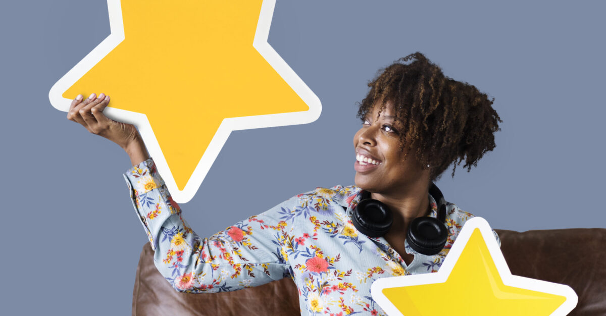 Cheerful woman holding golden stars icons